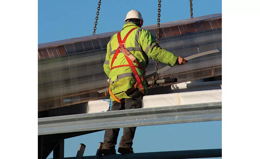 A Construction Worker Protected by a Guardrail and a Fall Arrest System