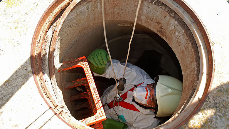 worker being lowered into confined space