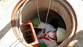 worker being lowered into confined space