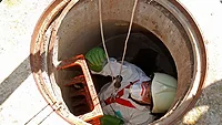worker being lowered into confined space
