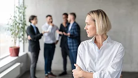 woman standing off from group of workers