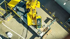 a yellow crane, a type of heavy lifting equipment used in construction and industrial settings. 