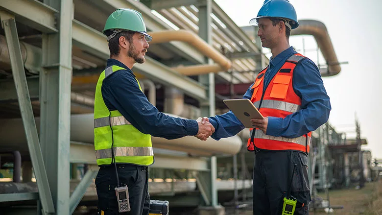 This image depicts a professional meeting between warehouse managers and engineers during a factory visit.